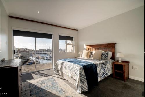 a bedroom with a bed and a balcony at Ships Bell at Port St Francis in St Francis Bay