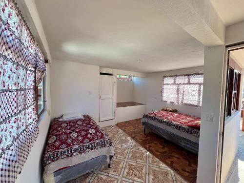 ein kleines Zimmer mit zwei Betten und einem Fenster in der Unterkunft Hotel Henderson in San Pedro La Laguna