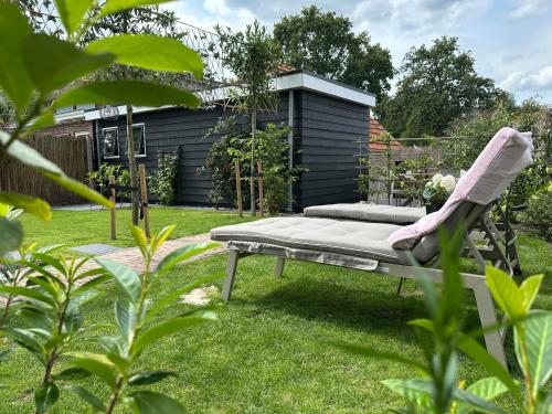 d'un jardin avec un banc dans la pelouse dans l'établissement Luxe Vakantiehuis met privé Wellness, à Zuidwolde