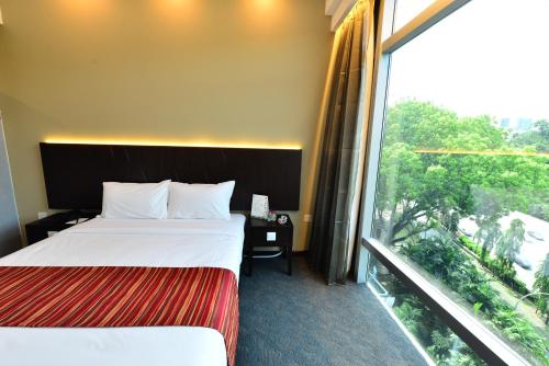 a hotel room with two beds and a large window at Hotel Chancellor@Orchard in Singapore