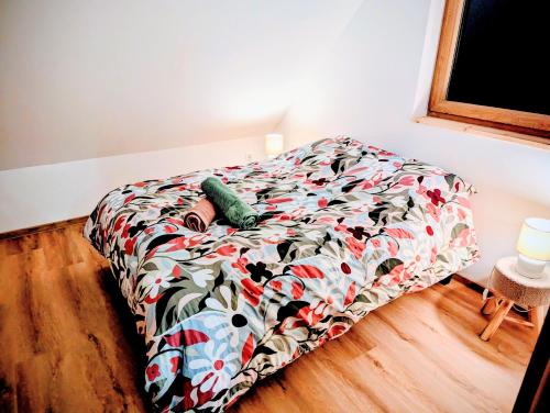 un letto con un piumone colorato in una camera da letto di Le Douillet 20' Strasbourg logement neuf CLIM a Marlenheim