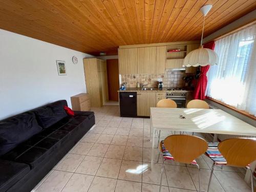 una sala de estar con un sofá, una mesa y sillas en Chalet Hofer, en Hasliberg Wasserwendi