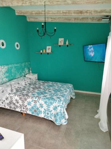 a bedroom with a bed and a green wall at Refugio Urbano Sentite como en casa en Comodoro Rivadavia in Comodoro Rivadavia