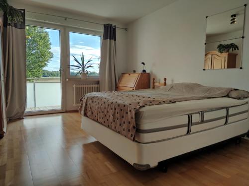 Un dormitorio con una cama grande y una ventana grande en La Datcha, en Unterschleißheim