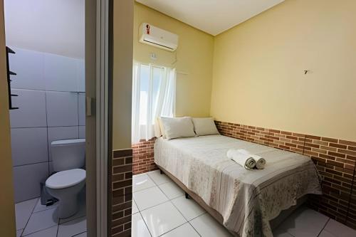 une petite chambre avec un lit et des toilettes dans l'établissement Pousada Caminho das Águas, à Santo Amaro