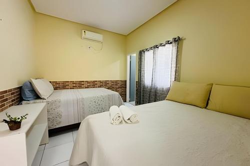 - une chambre avec 2 lits avec des chaussures dans l'établissement Pousada Caminho das Águas, à Santo Amaro