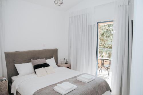 a white bedroom with a bed with towels on it at Villa Aphrodite in Paradise Gardens - 3bd with Private Pool by VICHY Holidays in Paphos