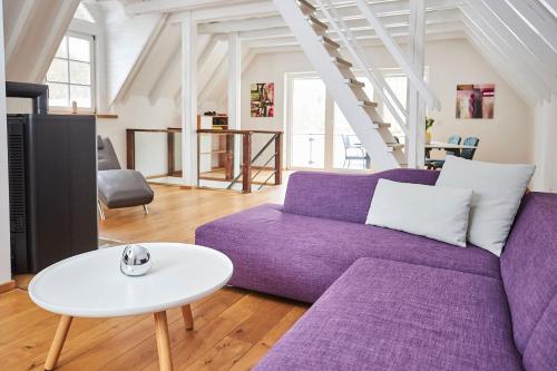 un salon avec un canapé violet et une table dans l'établissement Komfortables Ferienhaus In Purer Natur, à Edertal