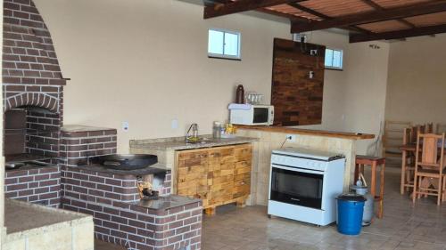 een keuken met een bakstenen oven en een fornuis bij Chácara Nonna Rosa in Socorro