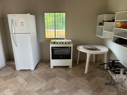 una cucina con un frigorifero bianco e un tavolo di Retiro Esperança a Santa Isabel do Pará