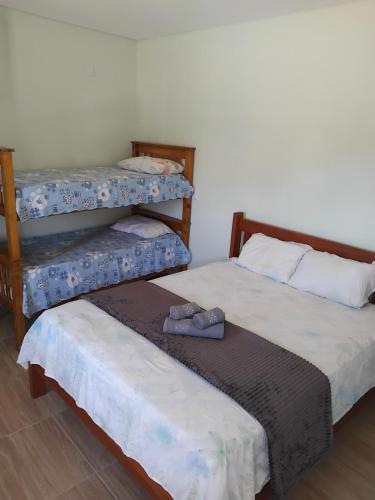 two beds with slippers on them in a room at Chácara Nonna Rosa in Socorro