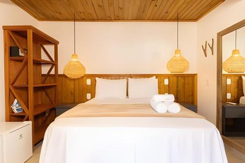a bedroom with a large bed with two towels at Suíte Charmosa na Mucugê - Café da manhã opcional - Conforto e Localização Perfeita in Porto Seguro