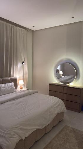 una camera da letto con un letto e uno specchio sul muro di شقة الفيصلية a Gedda