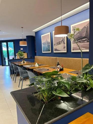Un comedor con mesas y sillas y plantas. en Transamerica Executive Higienópolis, en São Paulo