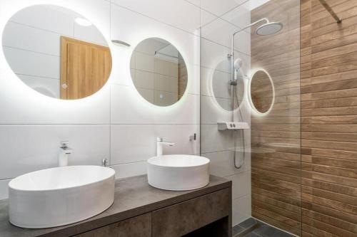 a bathroom with a white sink and two mirrors at Villa Eden with heated pool in Omiš