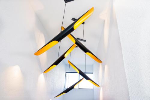 a chandelier with yellow and black sticks hanging from a wall at The Esplanade Motel in Batemans Bay