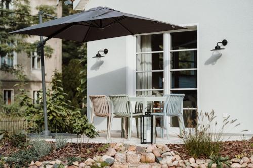 - une table et des chaises sous un parasol sur la terrasse dans l'établissement Spreewaldhaus Am Landgut Das Haupthaus, à Markische Heide