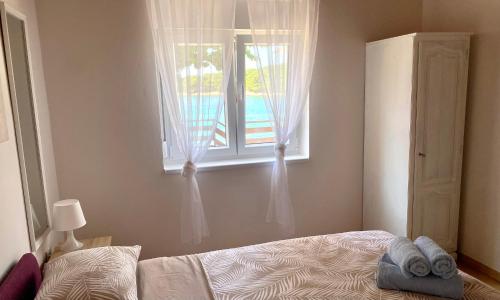 a bedroom with a bed and a window at Ždrelac Guest House in Ždrelac