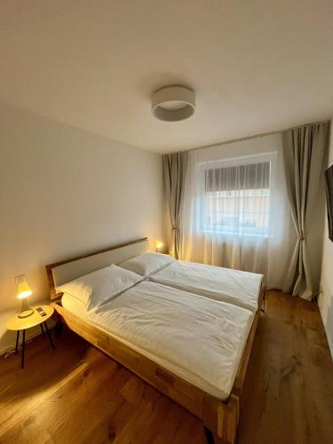 a bedroom with a large bed with a window at Verde Apartment in Svoboda nad Úpou