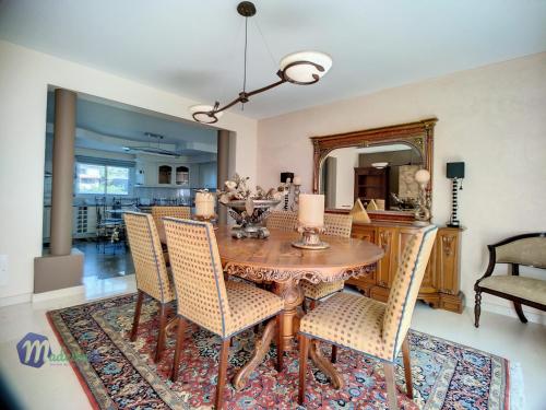 une salle à manger avec une table, des chaises et un miroir dans l'établissement Pearls Beach Villa, à Porto Moniz