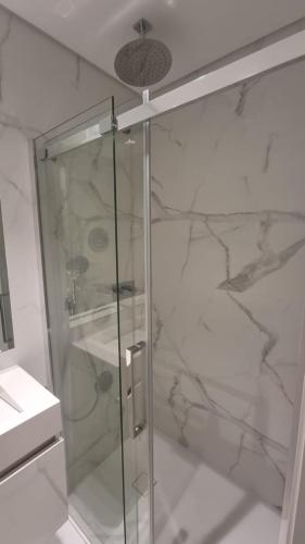 een douche met een glazen deur in een badkamer bij Braga 2 Bedrooms Nice Flat in Braga