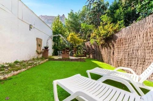 une cour avec deux chaises blanches et une clôture dans l'établissement Barceló Apartaments, à Monistrol de Montserrat