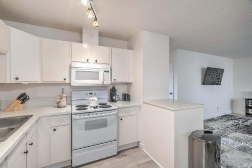 Una cocina con gabinetes blancos y una estufa y microondas. en Vegas Adventure Starts Here-Mins to Strip! Sleep 6!, en Las Vegas