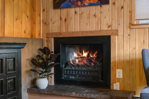 a fireplace in a living room with a fire in it at Cabin 1- Hot Tub Grill- Mins to RMNP in Estes Park