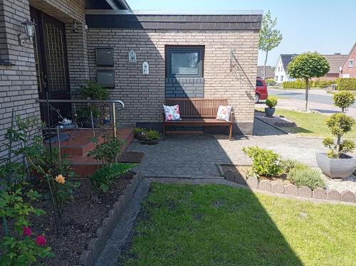 un patio avec un banc devant une maison dans l'établissement Ferienwohnung Zwei Finken In Wiesmoor, à Wiesmoor