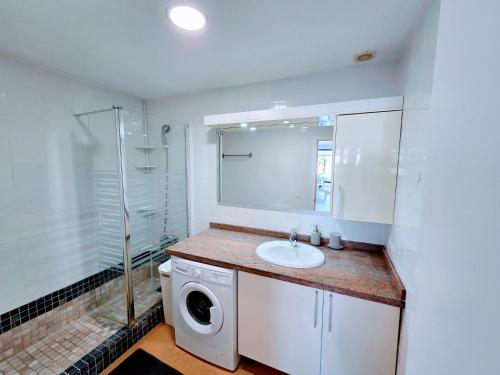 a bathroom with a washing machine and a sink at Canary Dreams Ocean View in Playa del Cura