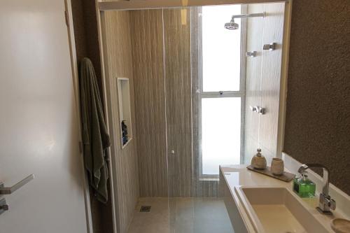 ein Badezimmer mit Waschbecken und Dusche mit Fenster in der Unterkunft Casa Boutique Pontal da Ilha - 5 suítes - 14 pessoas in Itamaracá