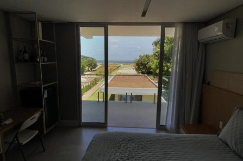 Schlafzimmer mit einem Bett und Blick auf ein Gebäude in der Unterkunft Casa Boutique Pontal da Ilha - 5 suítes - 14 pessoas in Itamaracá