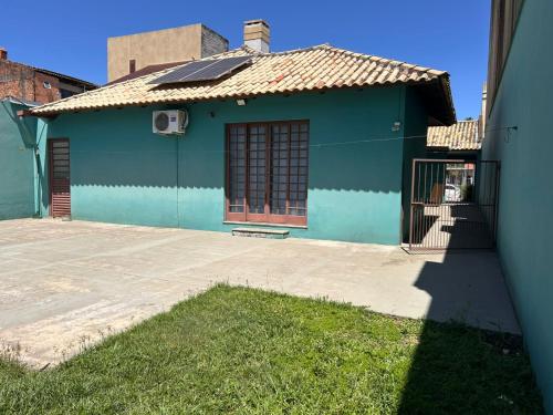 une maison bleue avec un portail devant dans l'établissement Andradas House - Casa em Uruguaiana, à Uruguaiana