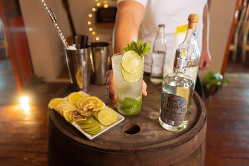 a person holding a drink and a bottle of alcohol at Hotel Colonial Abejorral in Abejorral