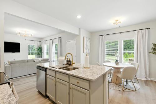 eine Küche und ein Wohnzimmer mit einem Waschbecken und einem Tisch in der Unterkunft New Listing The Neutral Nook with Firepit in Athens