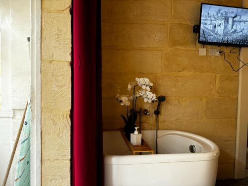 a bathroom with a tub with flowers in it at Phi Home Bormla in Birgu