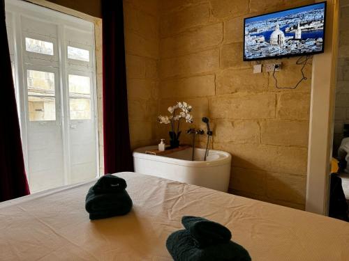 a bedroom with a sink and a bed with two towels at Phi Home Bormla in Birgu