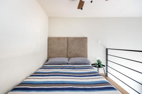 een slaapkamer met een bed met een gestreepte deken bij Hacienda Tapia in Monterrey