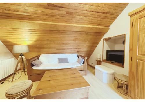 a small room with a bed and a tv at Bel appartement 4 à 6 personnes, ambiance chalet in Eaux-Bonnes