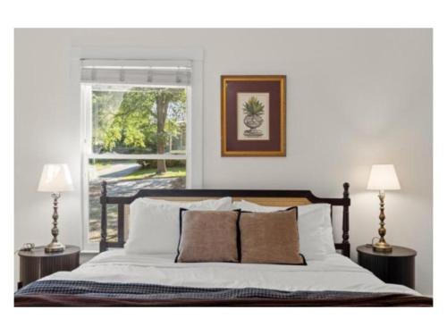 a bedroom with a bed with two lamps and a window at New listing! The Terra Cotta Bungalow with Firepit in Athens