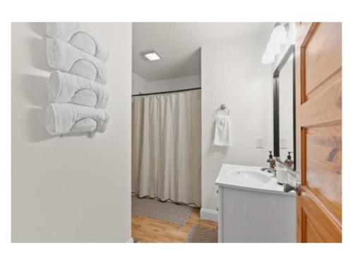 a bathroom with a sink and towels on a wall at New listing! The Terra Cotta Bungalow with Firepit in Athens