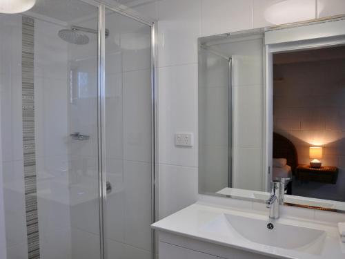 a bathroom with a shower and a sink and a mirror at Palm Waters Holiday Villas in Townsville
