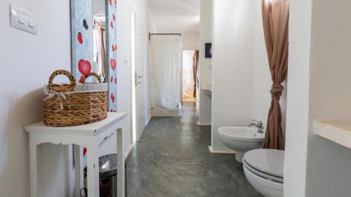 Un baño blanco con inodoro y lavabo. en BALiPALAZEVILLA, en Tanah Lot