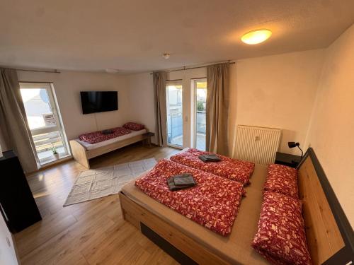 a large room with two beds and a television at City Apart am MUSEUM nahe BADEWELT in Sinsheim