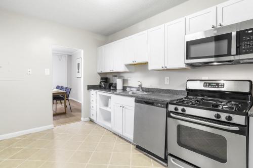 a kitchen with stainless steel appliances and white cabinets at Modern Apt in Crystal City Near the Airport in Arlington