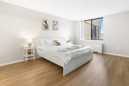 a white bedroom with a bed and a window at Modern Apt in Crystal City Near the Airport in Arlington