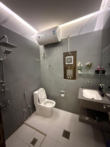 a bathroom with a white toilet and a sink at Ryhana apartment in Al Ain