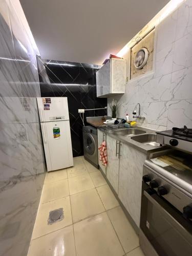 a kitchen with a sink and a refrigerator at Ryhana apartment in Al Ain