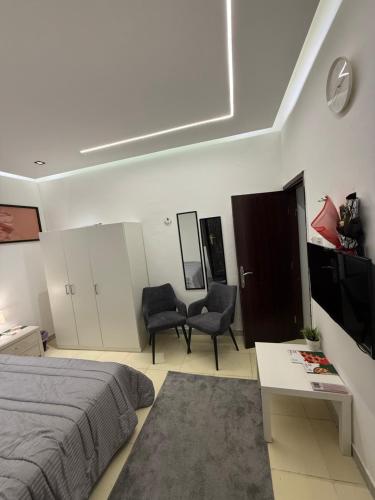 a bedroom with a bed and a table and chairs at Ryhana apartment in Al Ain