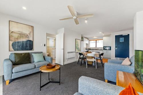 a living room with two couches and a table at 6 on Adams in Mount Maunganui